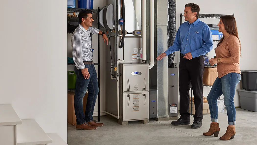 Naugle technician walking homeowners through their new high-efficiency Carrier furnace