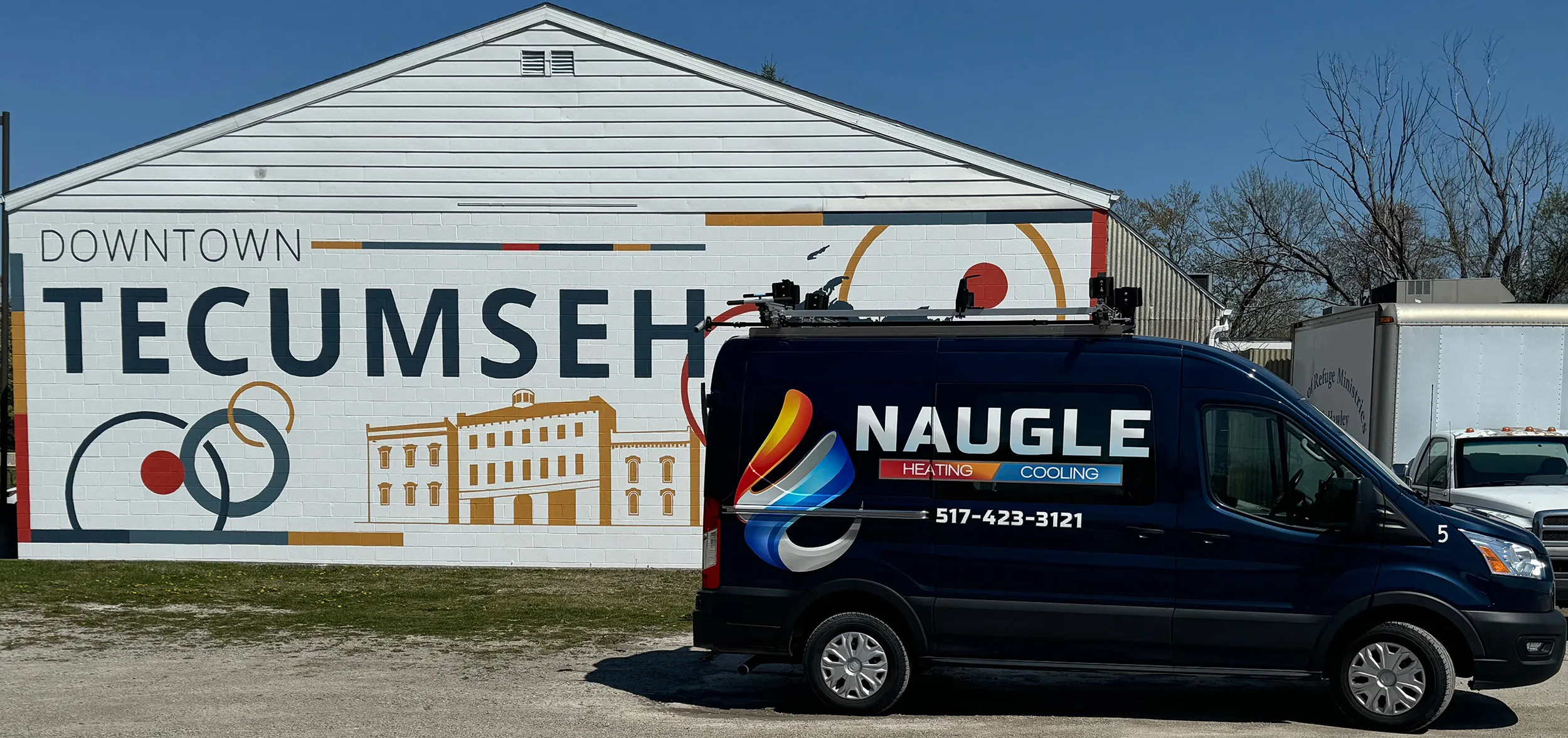 Naugle service van in front of the Downtown Tecumseh mural